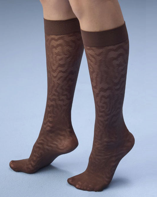 A pair of sheer brown knee-high socks with a textured wavy pattern, shown on a model's legs against a light blue studio background.