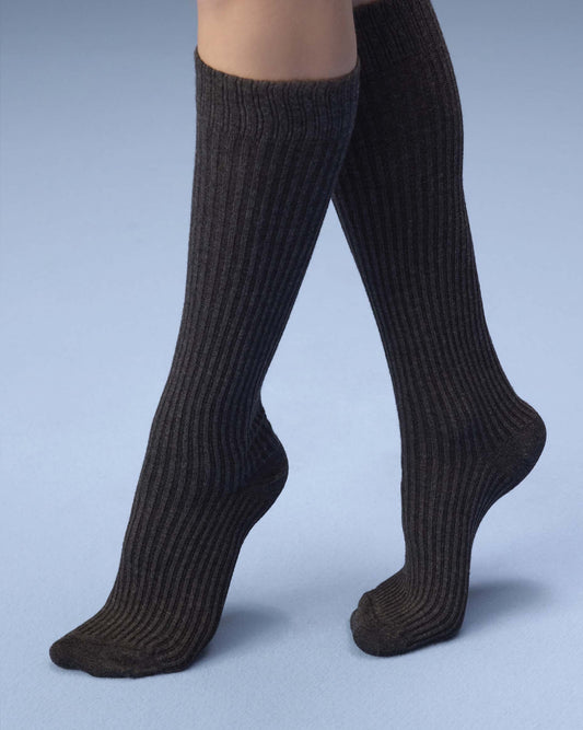 A pair of ribbed knee-high socks worn on legs, shown against a light blue studio background.
