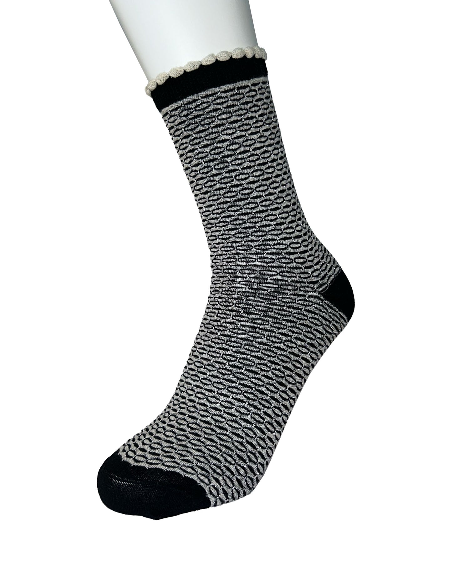 Black and white patterned sock on a mannequin foot against a white background